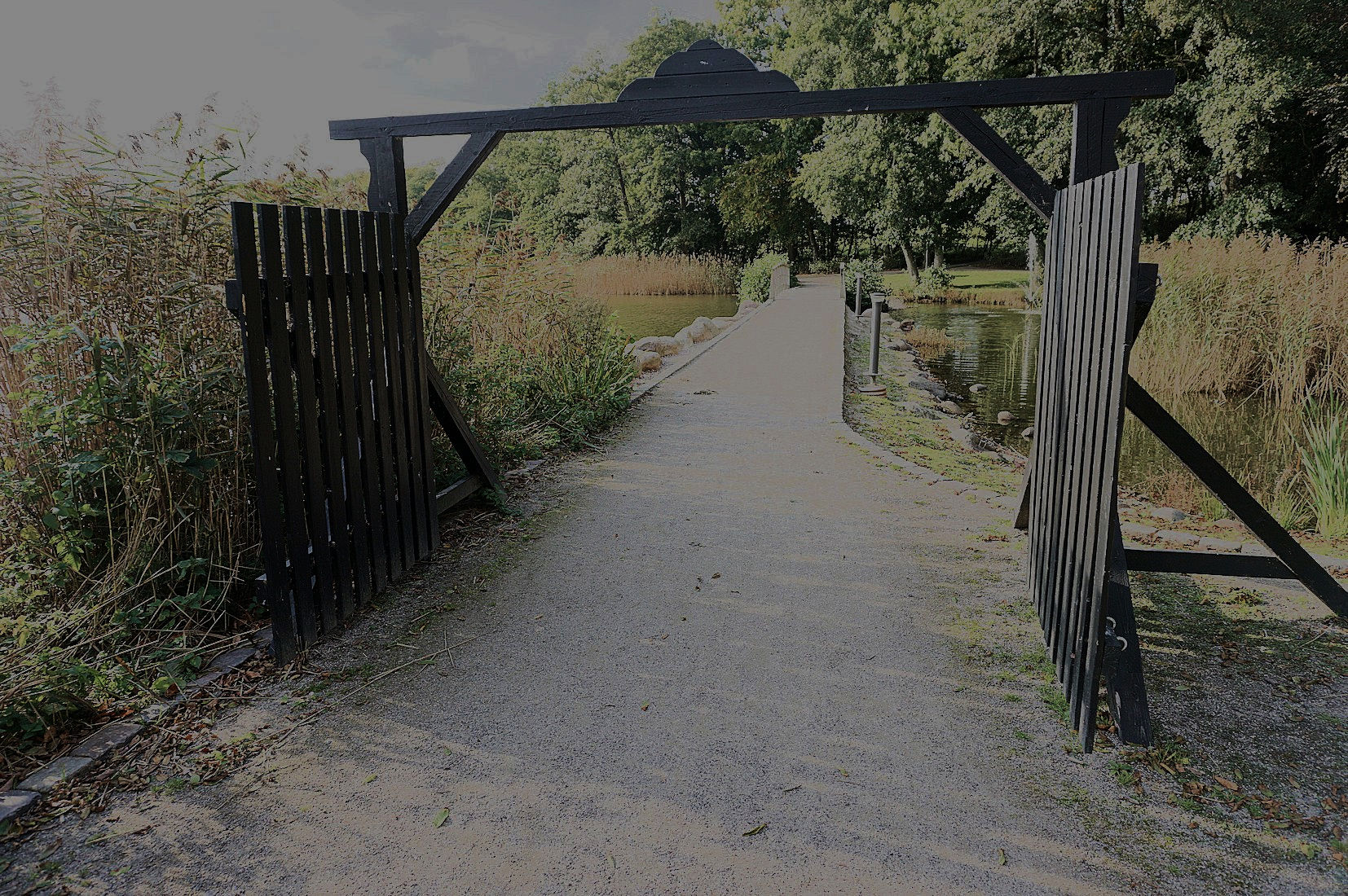 Kongeporten her er en lidt mindre kopi af porten ind til den kongelige jagtejendom i Trend. Porten blev lavet af elever fra tømrerlinjen på HEG i Aars.